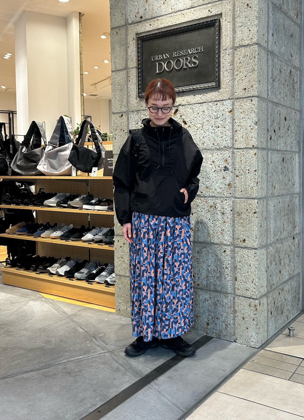 ブラック系のパーカー、ブルー系のスカートを着用したレディースの春コーディネートの4枚目の写真