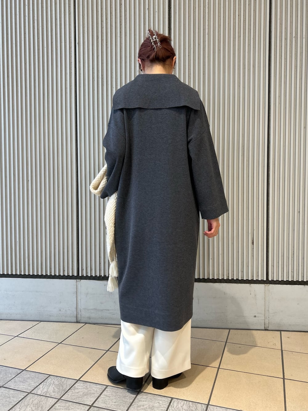 グレー系のワンピース、ホワイト系のその他パンツ、ブラック系のボストンバッグを着用したレディースの秋コーディネートの6枚目の写真