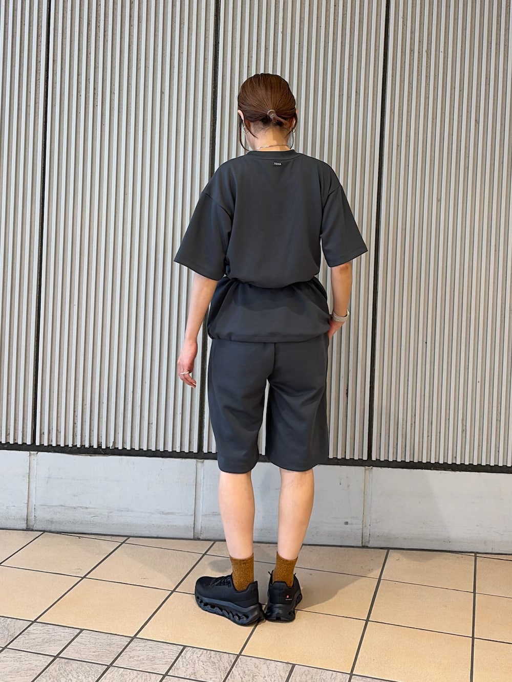 ブラック系のスニーカー、グレー系のルームウェア/パジャマ、ブラック系のポーチを着用したレディースの夏コーディネートの3枚目の写真