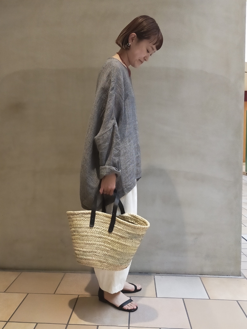 グレー系のシャツ/ブラウス、ホワイト系のその他パンツ、ブラック系のかごバッグを着用したレディースの春コーディネートの2枚目の写真