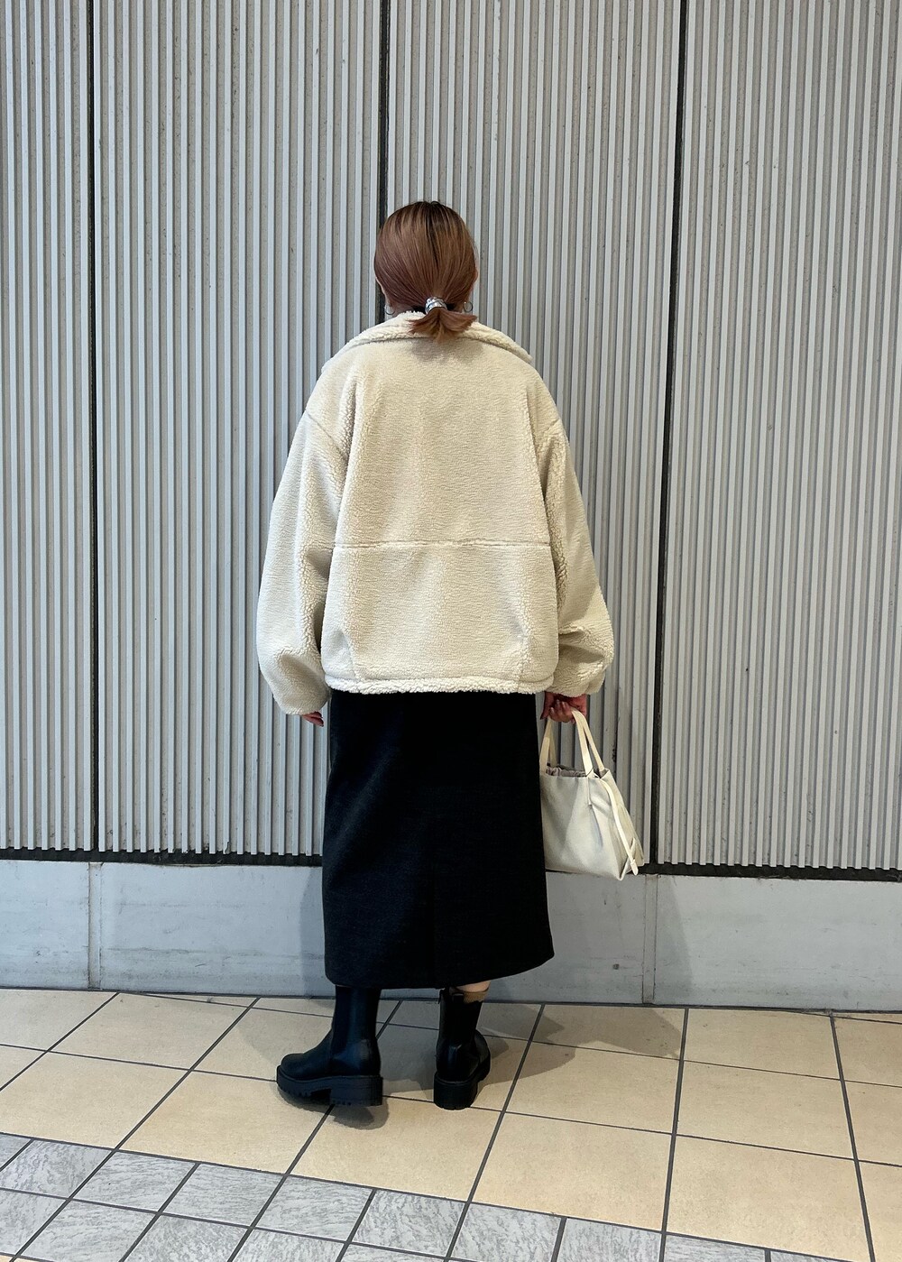 ホワイト系のその他アウター、グレー系のワンピース、ブラック系のブーツを着用したレディースの冬コーディネートの3枚目の写真