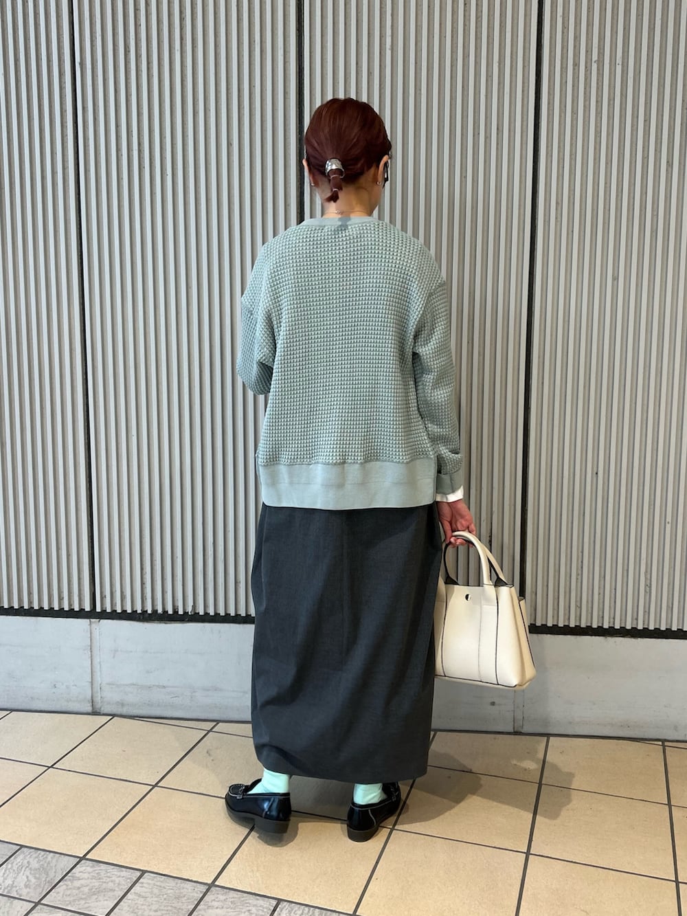 グリーン系のカーディガン/ボレロ、グレー系のワンピース、ブラック系のローファーを着用したレディースの冬コーディネートの2枚目の写真