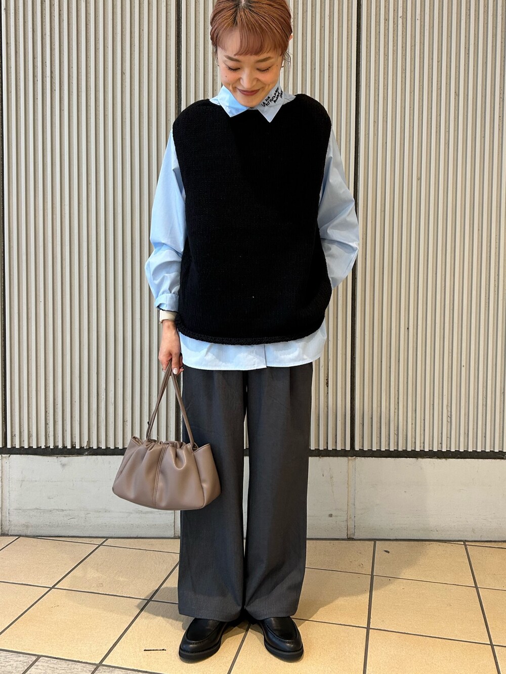 ブラック系のニット/セーター、ブルー系のシャツ/ブラウス、グレー系のその他パンツを着用したレディースの秋コーディネートの4枚目の写真