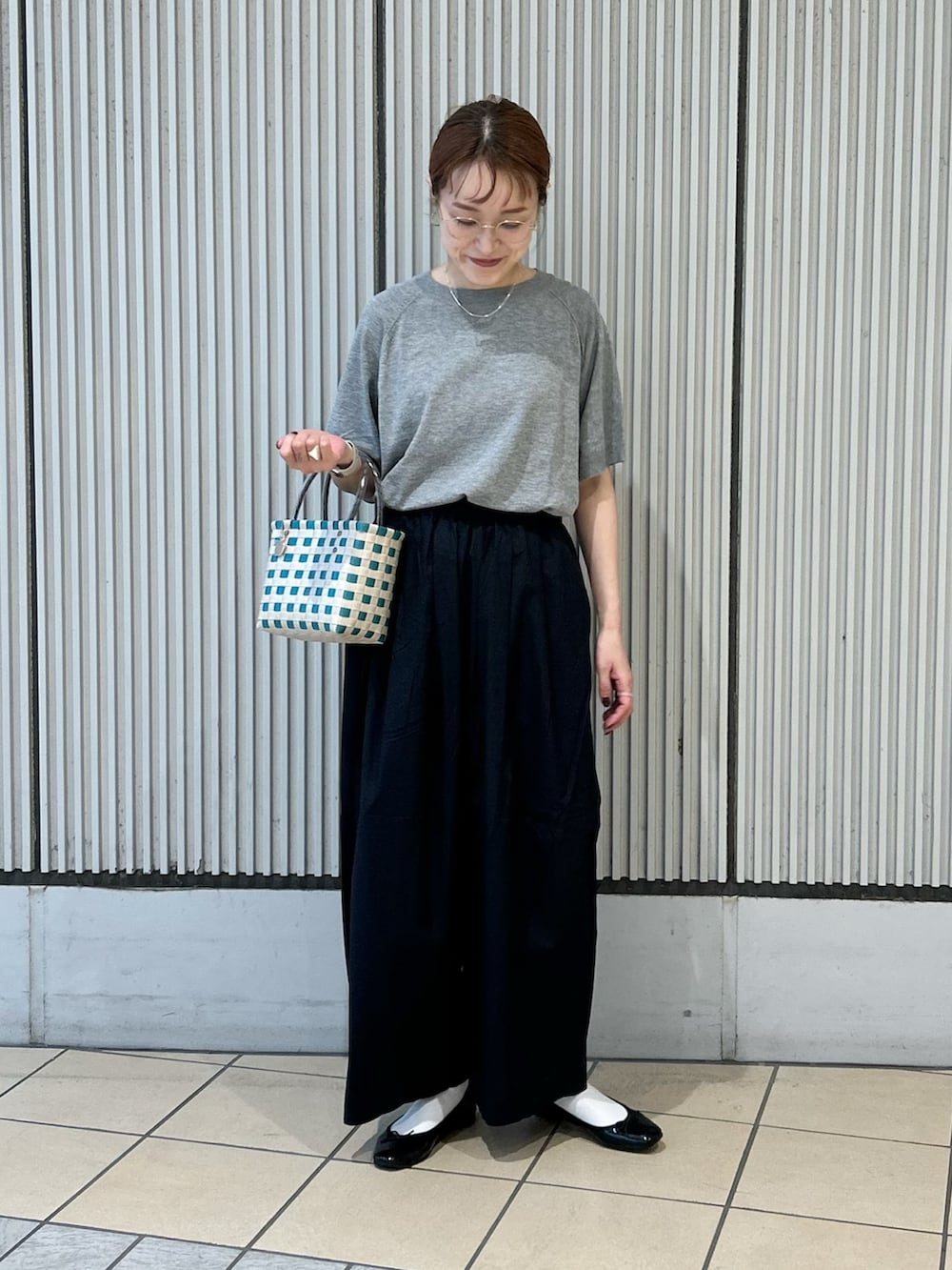 グレー系のニット/セーター、ブラック系のその他パンツ、シルバー系のネックレスを着用したレディースの夏コーディネートの3枚目の写真