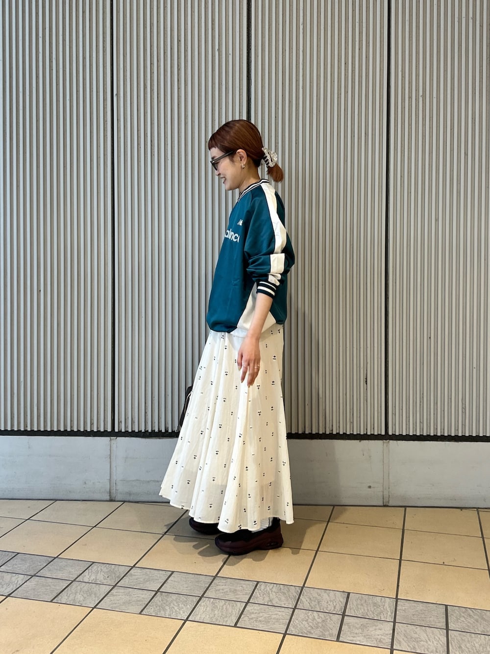 ホワイト系のスカート、グリーン系のその他トップス、レッド系のスニーカーを着用したレディースの春コーディネートの2枚目の写真