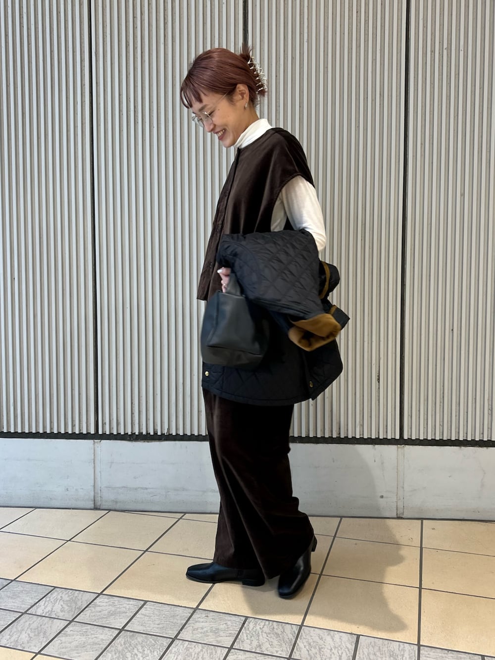 ブラック系のその他アウター、ブラック系のハンドバッグ、ホワイト系のTシャツ/カットソーを着用したレディースの秋コーディネートの5枚目の写真