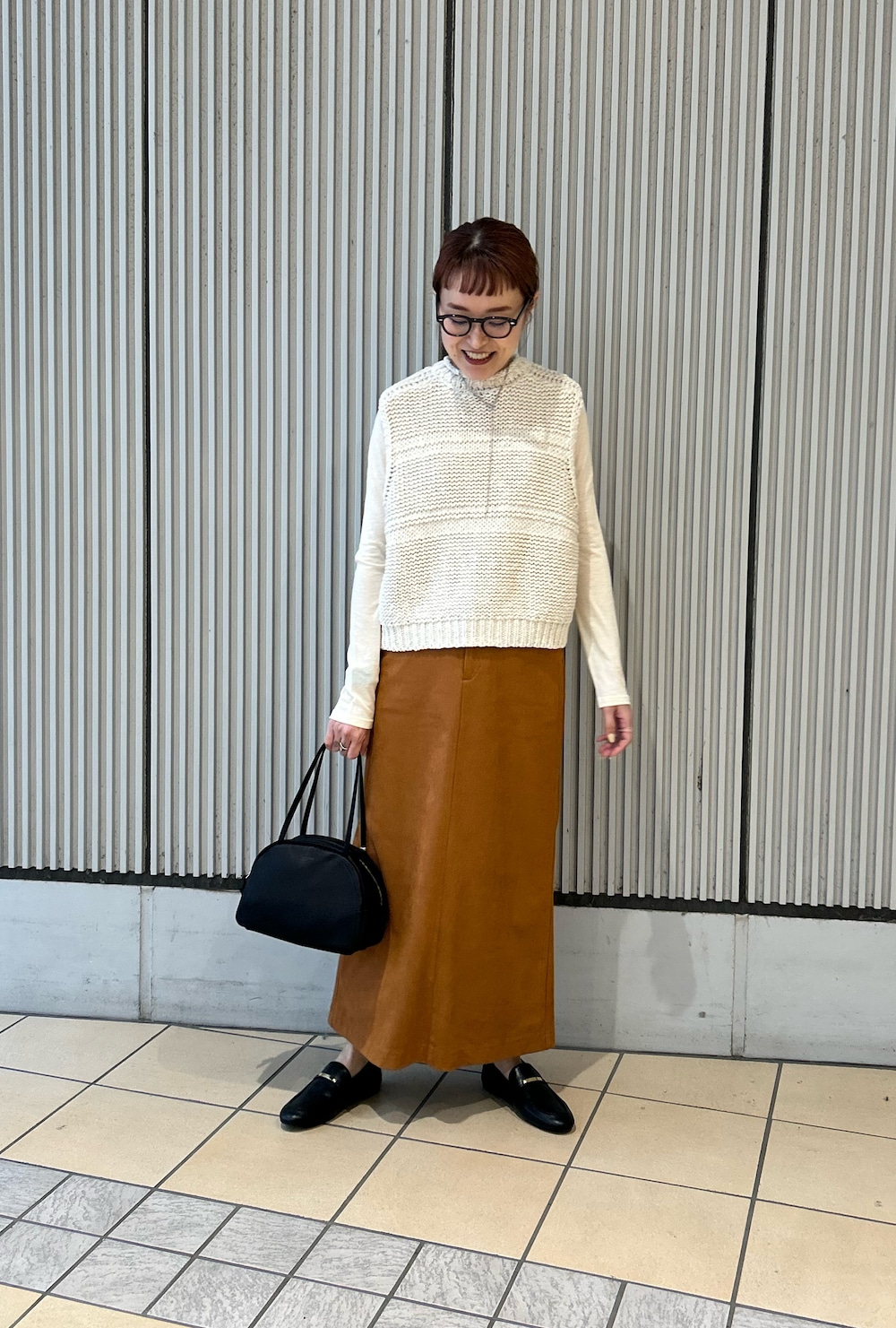 ホワイト系のベスト、ホワイト系のTシャツ/カットソー、ブラック系のローファーを着用したレディースの春コーディネートの3枚目の写真