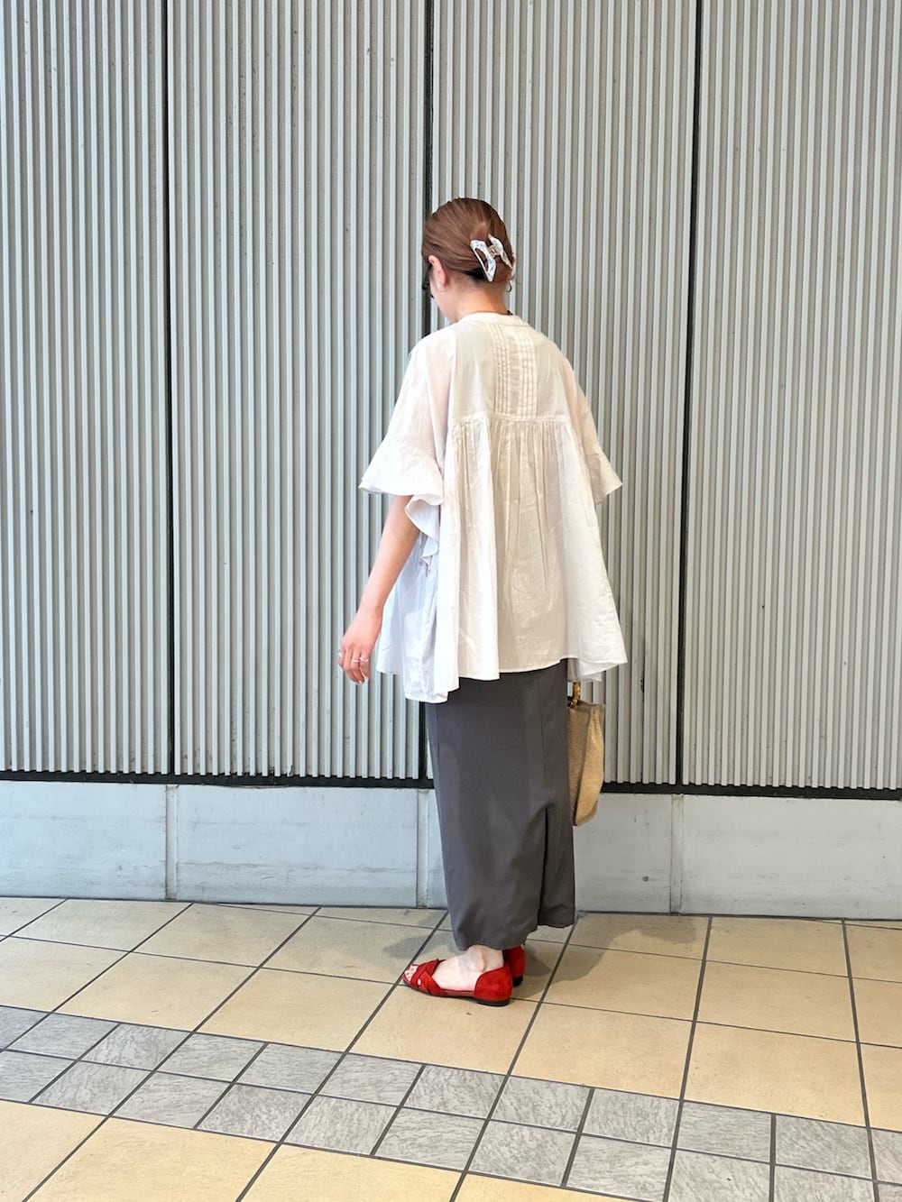 グレー系のシャツ/ブラウス、グレー系のスカート、ベージュ系のショルダーバッグを着用したレディースの春コーディネートの2枚目の写真