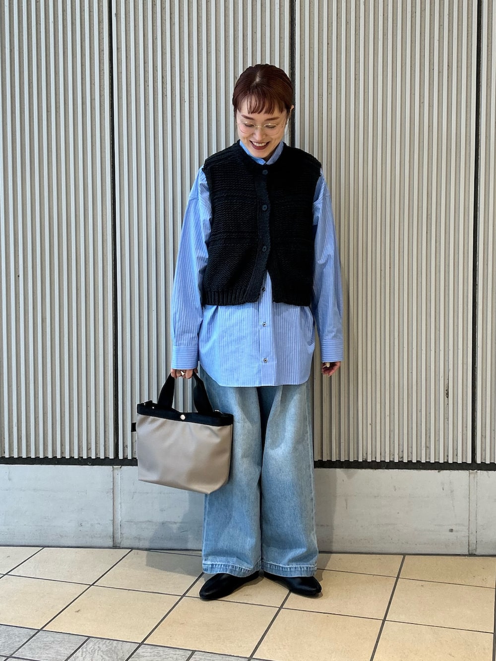 ブラック系のベスト、ブルー系のシャツ/ブラウス、ブルー系のデニムパンツを着用したレディースの冬コーディネートの4枚目の写真