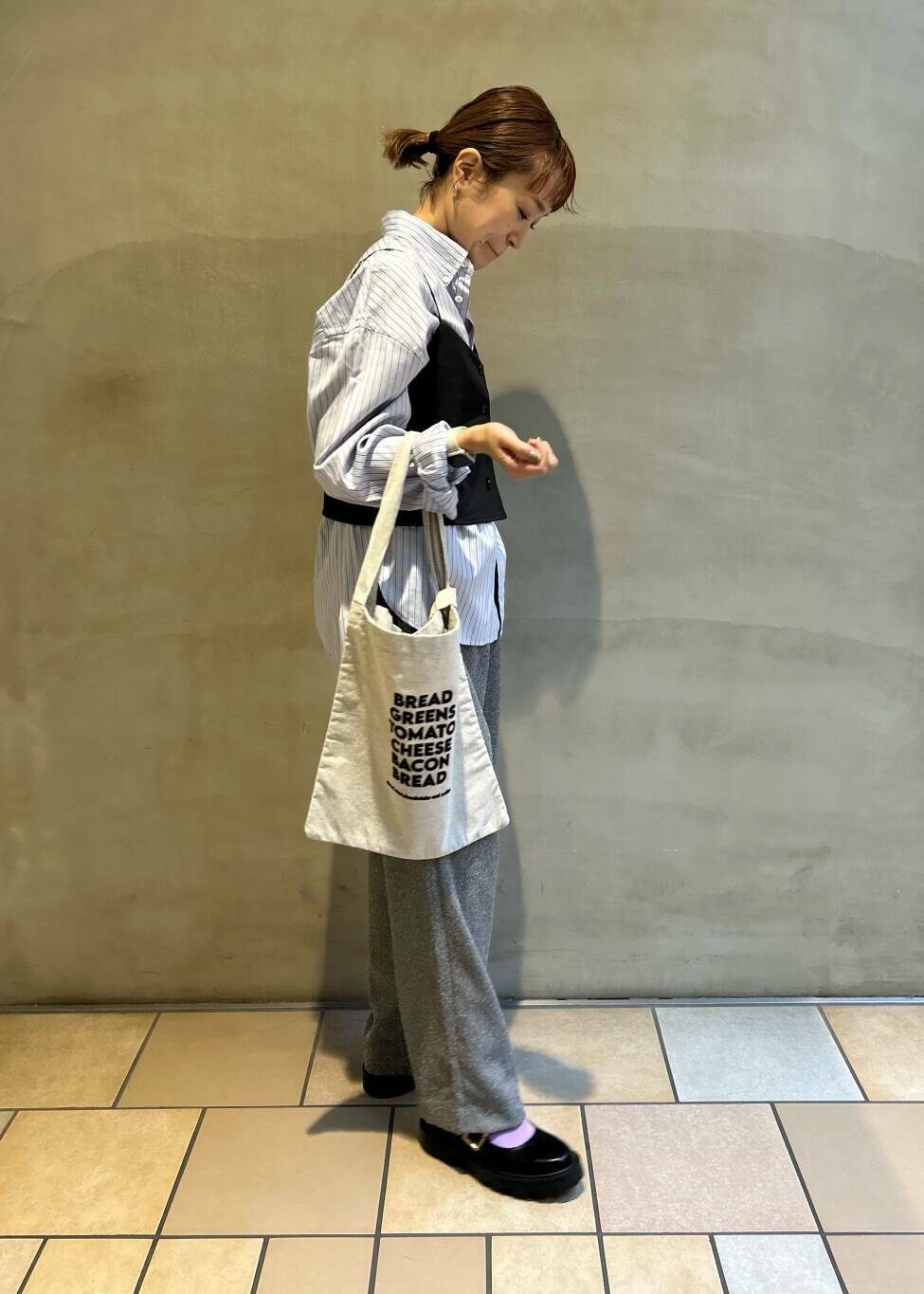 グレー系のその他パンツ、グレー系のトートバッグ、ブルー系のシャツ/ブラウスを着用したレディースの秋コーディネートの4枚目の写真