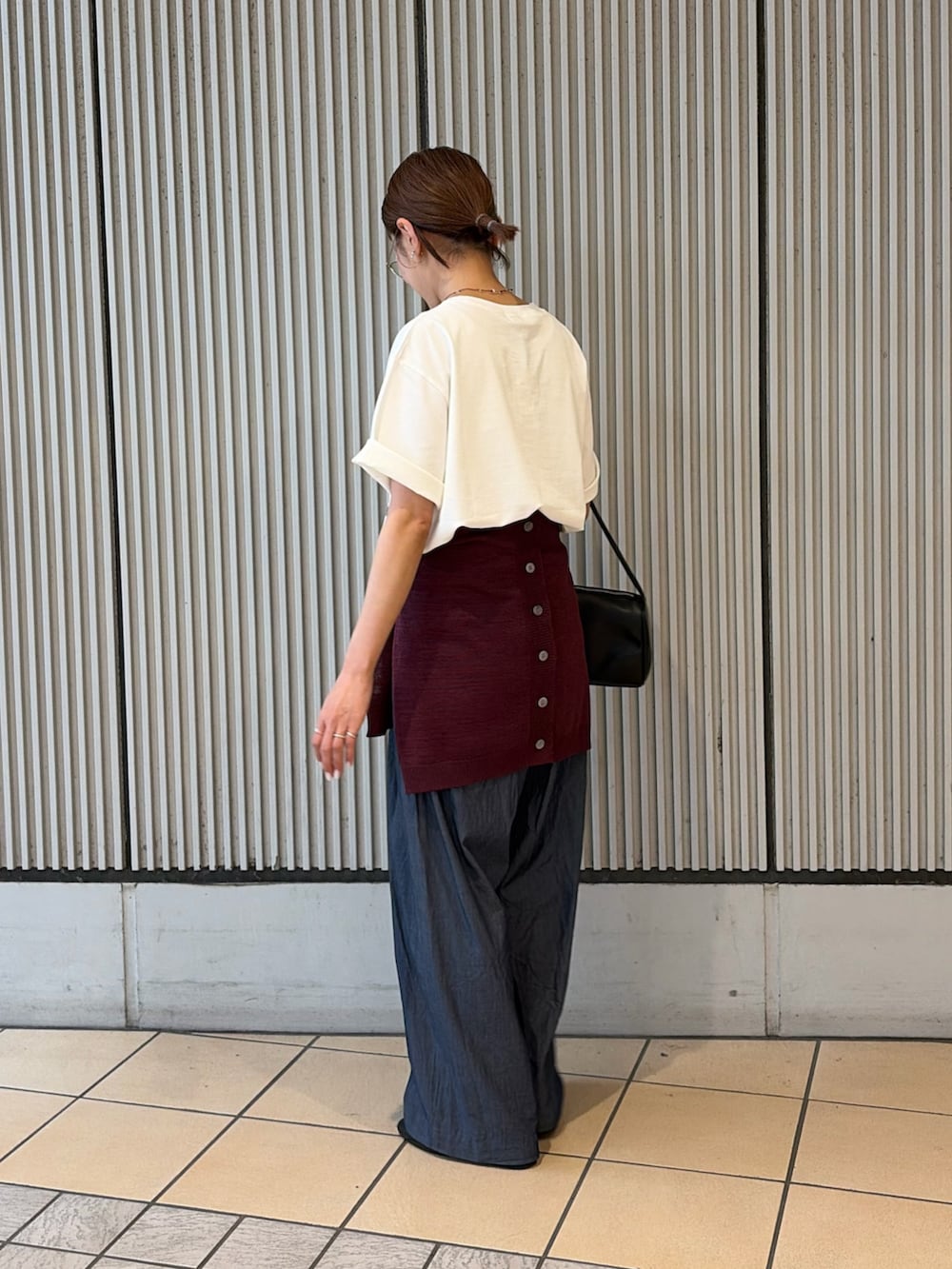 ホワイト系のTシャツ/カットソー、ブルー系のデニムパンツ、ブラック系のハンドバッグを着用したレディースの夏コーディネートの2枚目の写真
