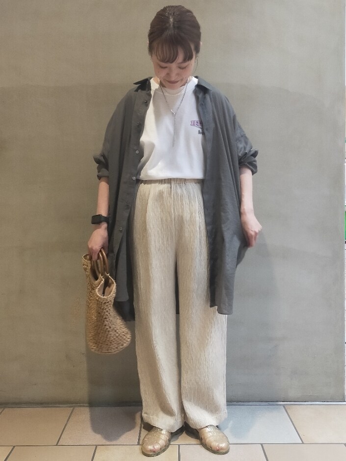 グリーン系のシャツ/ブラウス、ベージュ系のその他パンツ、ベージュ系のかごバッグを着用したレディースの春コーディネートの4枚目の写真