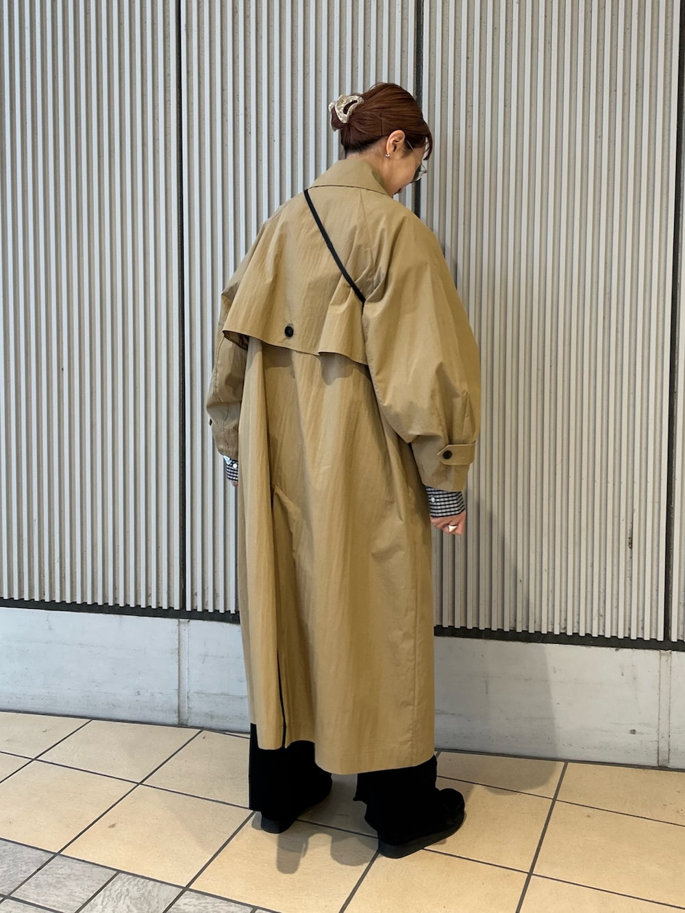 ベージュ系のトレンチコート、ブラック系のシャツ/ブラウス、ブラック系のその他パンツを着用したレディースの冬コーディネートの3枚目の写真