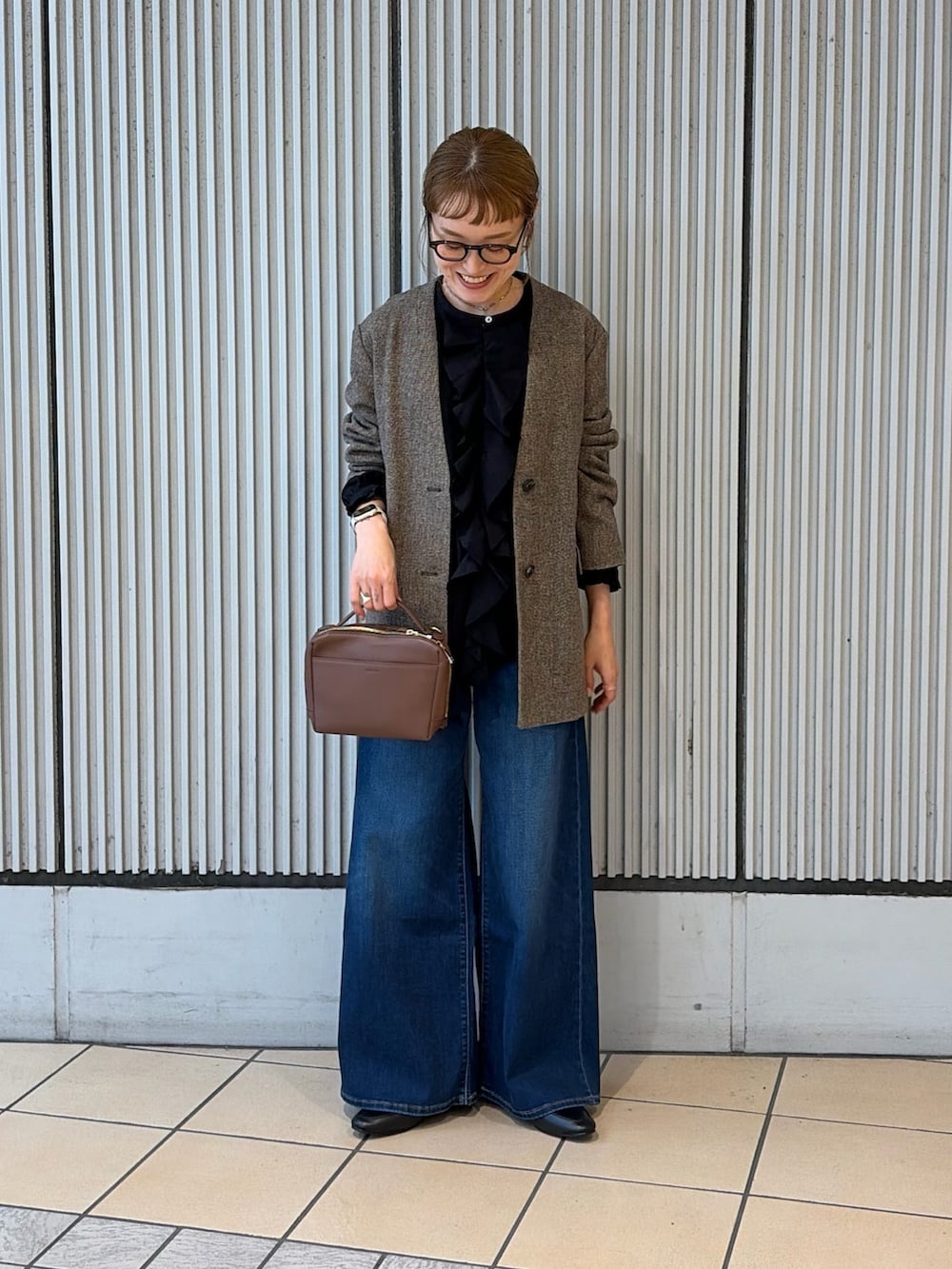 ブルー系のデニムパンツ、ブラウン系のノーカラージャケット、ブラック系のシャツ/ブラウスを着用したレディースの秋コーディネートの4枚目の写真