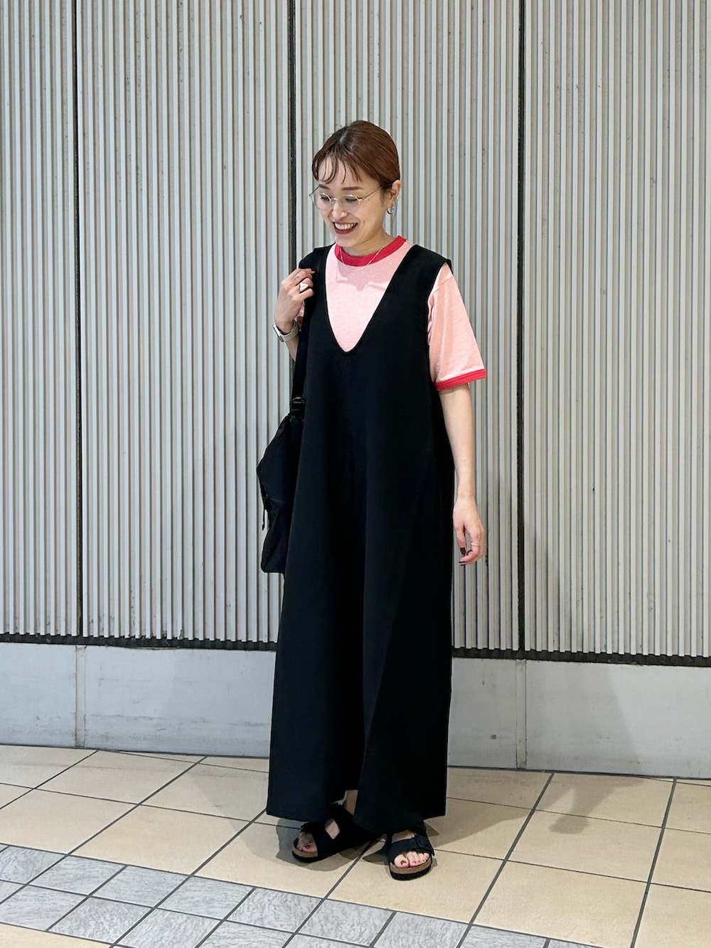 ブラック系のワンピース、レッド系のTシャツ/カットソー、ブラック系のサンダルを着用したレディースの夏コーディネートの3枚目の写真