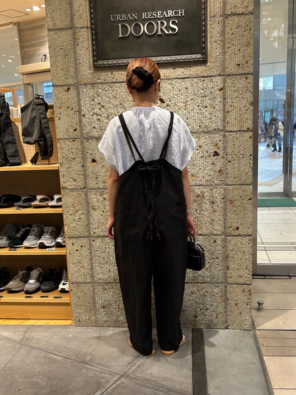 ブラック系のサロペット/オーバーオール、ブルー系のシャツ/ブラウス、ブラック系のショルダーバッグを着用したレディースの春コーディネートの3枚目の写真