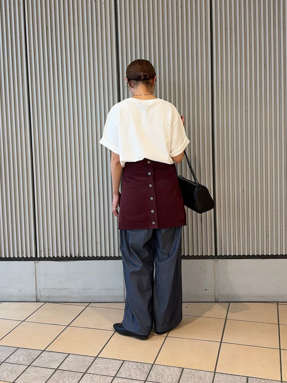 ホワイト系のTシャツ/カットソー、ブルー系のデニムパンツ、ブラック系のハンドバッグを着用したレディースの夏コーディネートの3枚目の写真