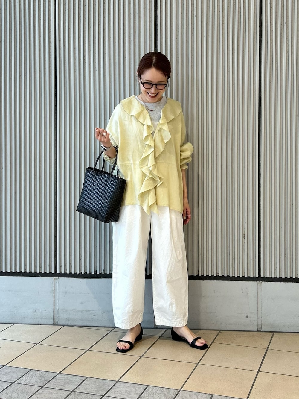 イエロー系のシャツ/ブラウス、ホワイト系のその他パンツ、ブラック系のサンダルを着用したレディースの春コーディネートの4枚目の写真