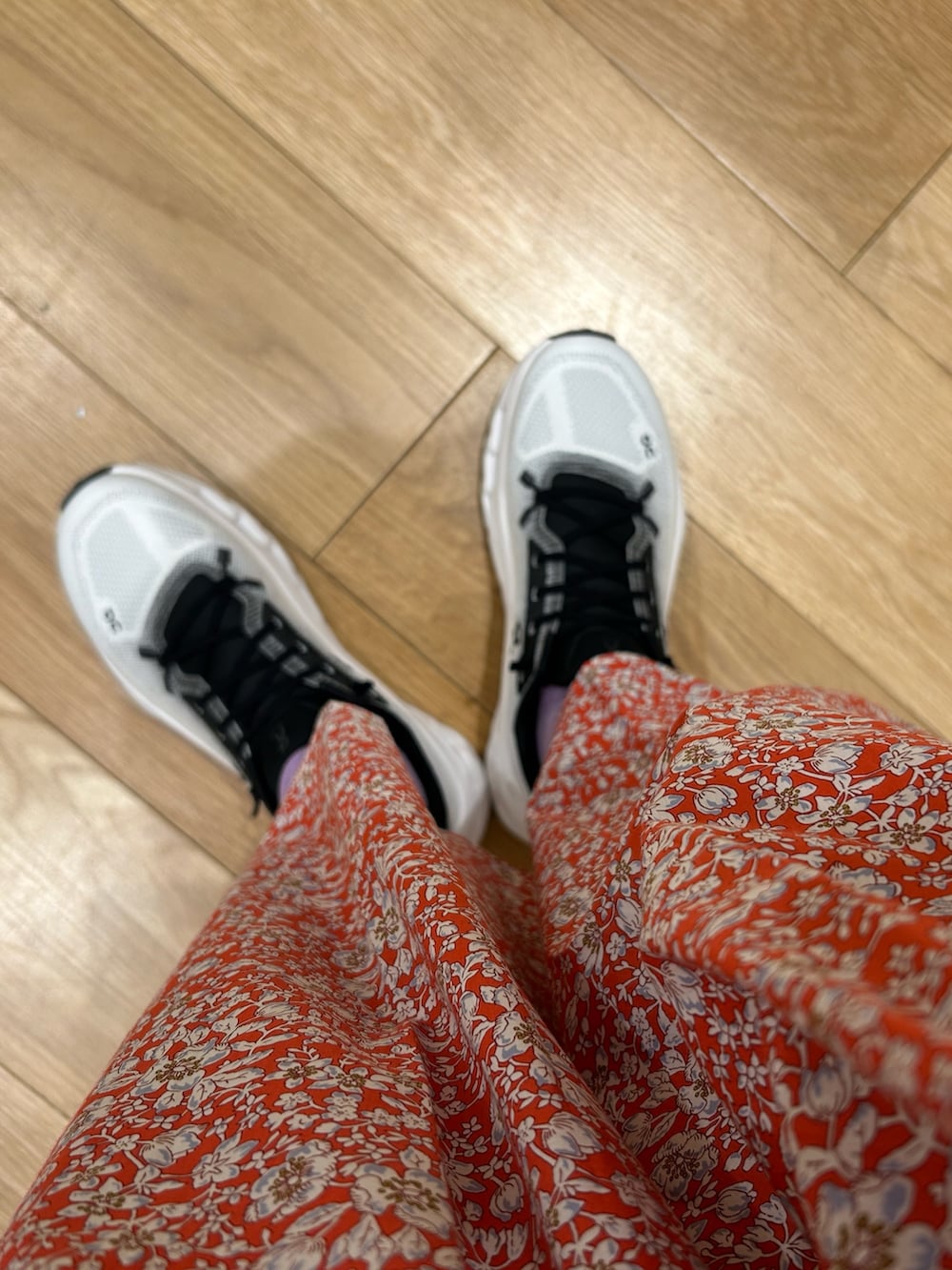 レッド系のスカート、グレー系のニット/セーター、ブラック系のスニーカーを着用したレディースの春コーディネートの5枚目の写真