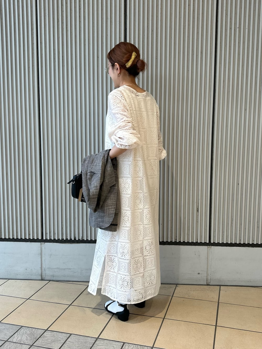 ベージュ系のワンピース、ブラック系のサンダル、ブラック系のショルダーバッグを着用したレディースの春コーディネートの2枚目の写真