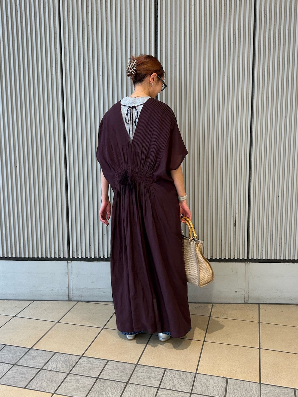 ブラウン系のワンピース、グレー系のTシャツ/カットソー、ベージュ系のショルダーバッグを着用したレディースの春コーディネートの2枚目の写真
