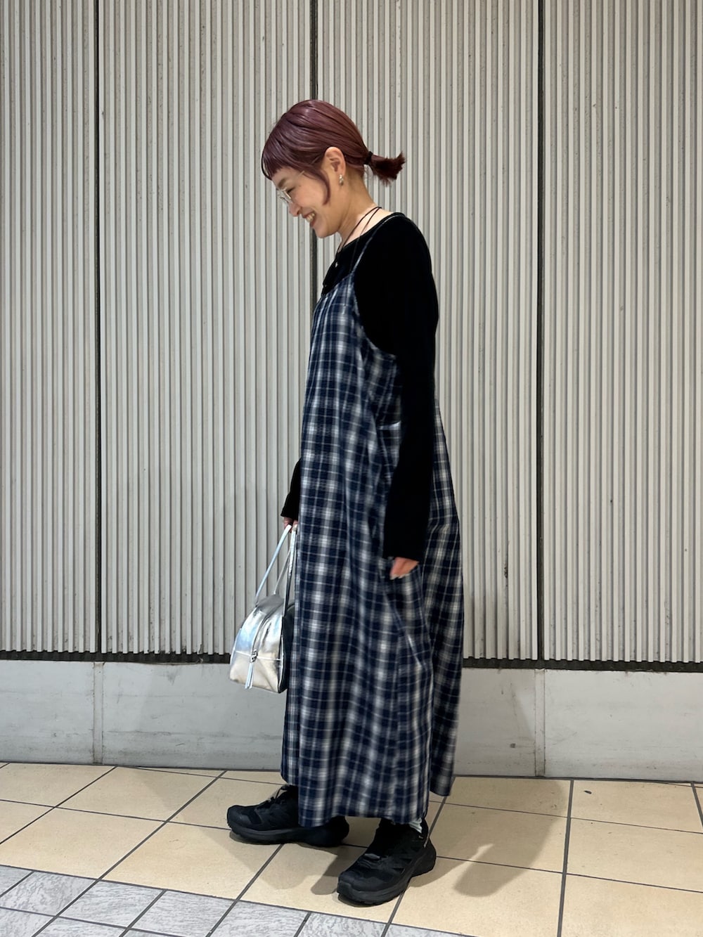 ブルー系のワンピース、ブラック系のTシャツ/カットソー、シルバー系のボストンバッグを着用したレディースの秋コーディネートの2枚目の写真