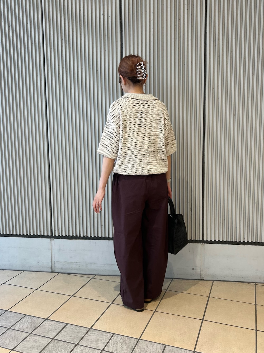 ベージュ系のニット/セーター、ブラック系のハンドバッグ、ブラック系のサンダルを着用したレディースの春コーディネートの2枚目の写真