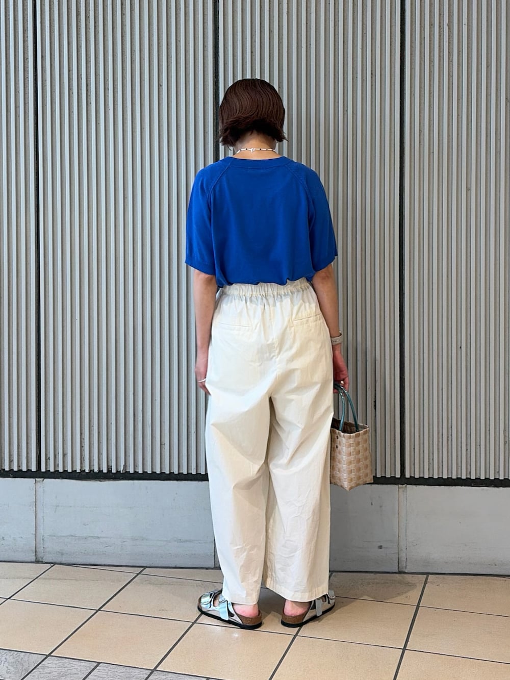 ブルー系のニット/セーター、ホワイト系のその他パンツ、シルバー系のサンダルを着用したレディースの夏コーディネートの3枚目の写真