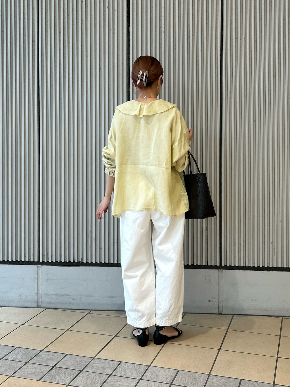 イエロー系のシャツ/ブラウス、ホワイト系のその他パンツ、ブラック系のサンダルを着用したレディースの春コーディネートの3枚目の写真