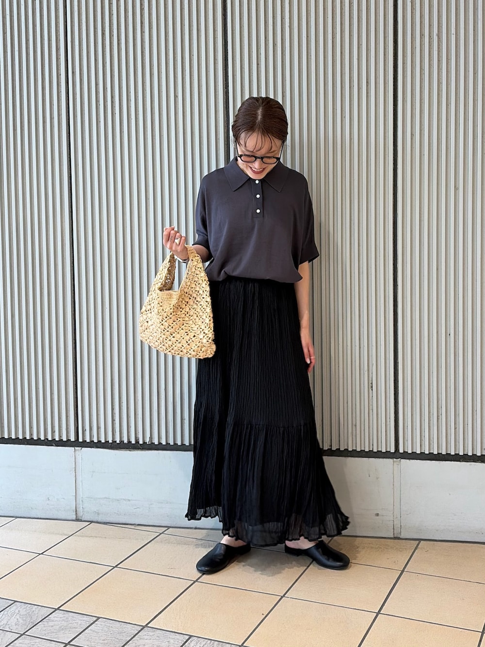 グレー系のニット/セーター、ブラック系のスカート、ブラック系のその他シューズを着用したレディースの夏コーディネートの3枚目の写真