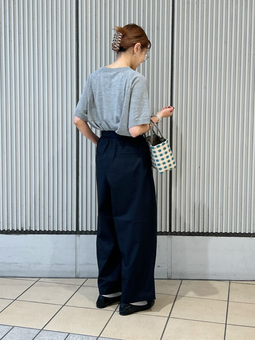 グレー系のニット/セーター、ブラック系のその他パンツ、シルバー系のネックレスを着用したレディースの夏コーディネートの2枚目の写真