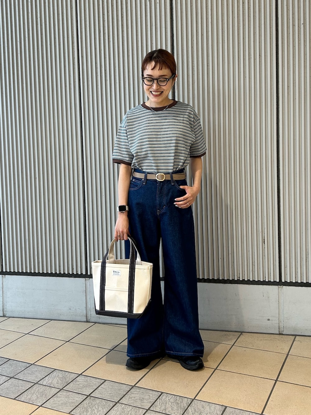 ホワイト系のトートバッグ、ブルー系のデニムパンツ、ブルー系のTシャツ/カットソーを着用したレディースの春コーディネートの3枚目の写真