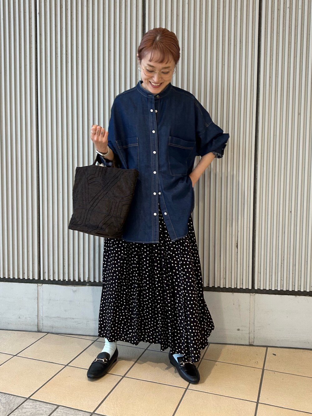 ブルー系のシャツ/ブラウス、ブラック系のスカート、ブラック系のパンプスを着用したレディースの秋コーディネートの4枚目の写真