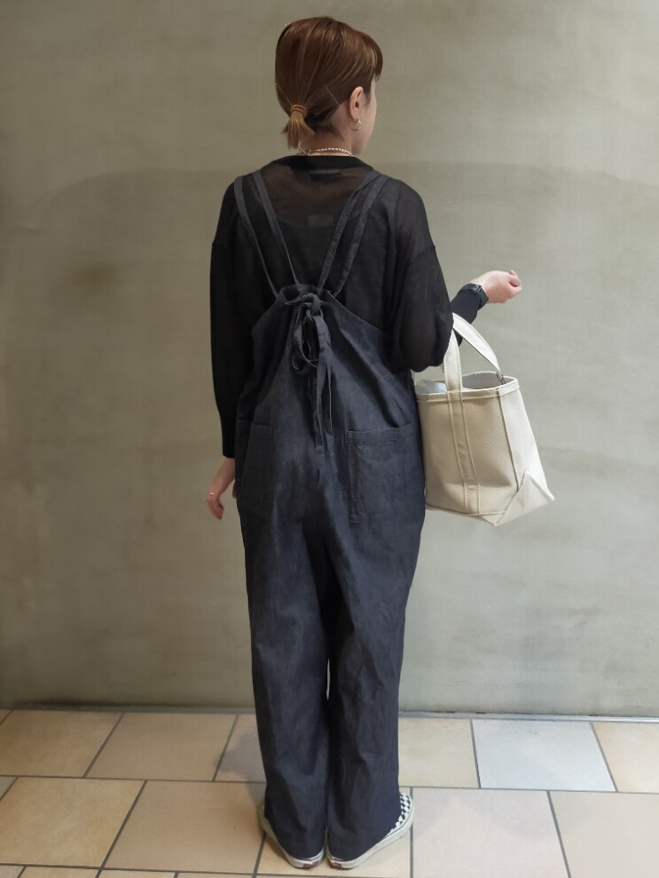 ブルー系のオールインワン・サロペット、ホワイト系のトートバッグ、ブラック系のニット/セーターを着用したレディースの夏コーディネートの4枚目の写真