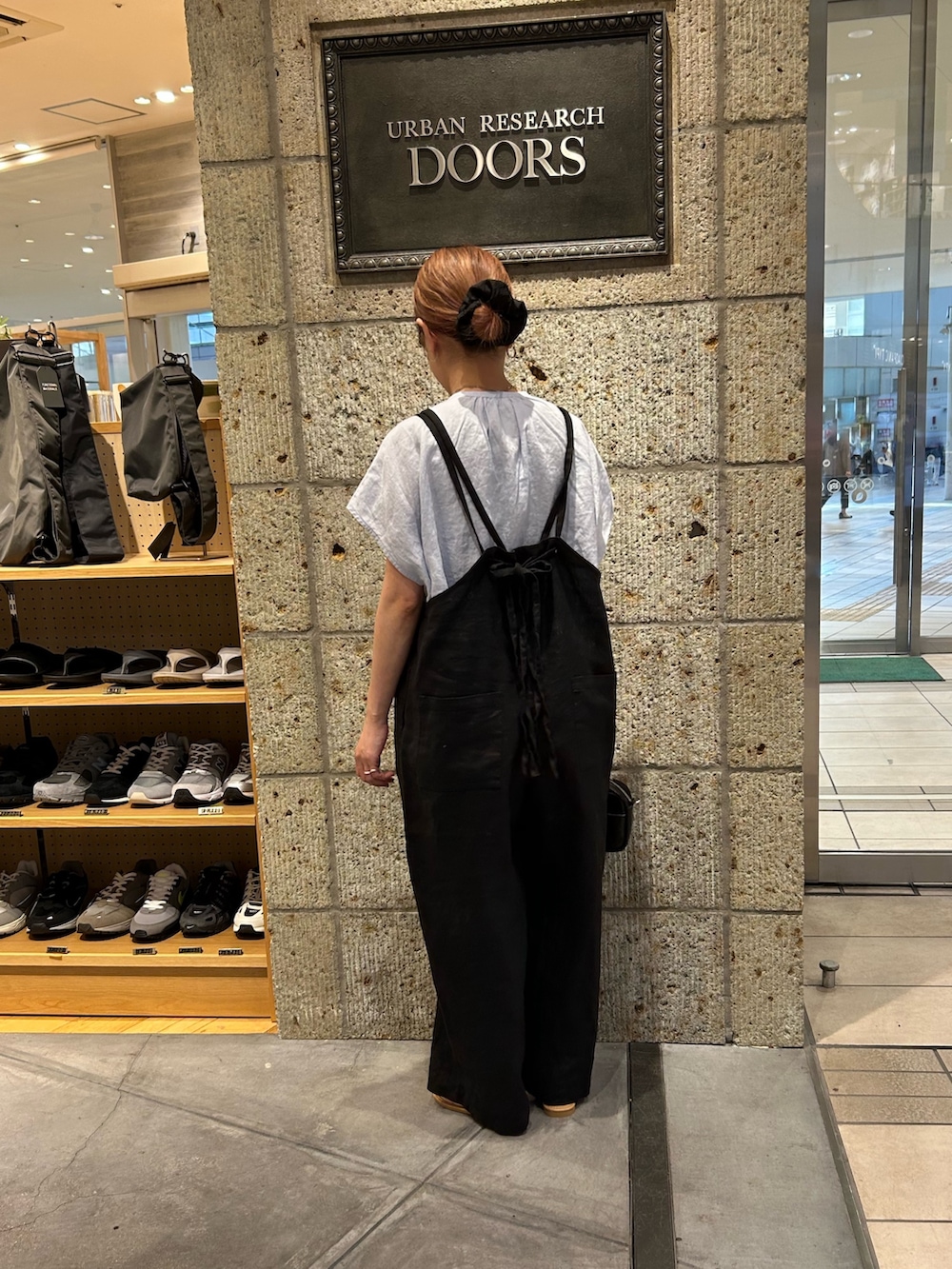 ブラック系のサロペット/オーバーオール、ブルー系のシャツ/ブラウス、ブラック系のショルダーバッグを着用したレディースの春コーディネートの2枚目の写真