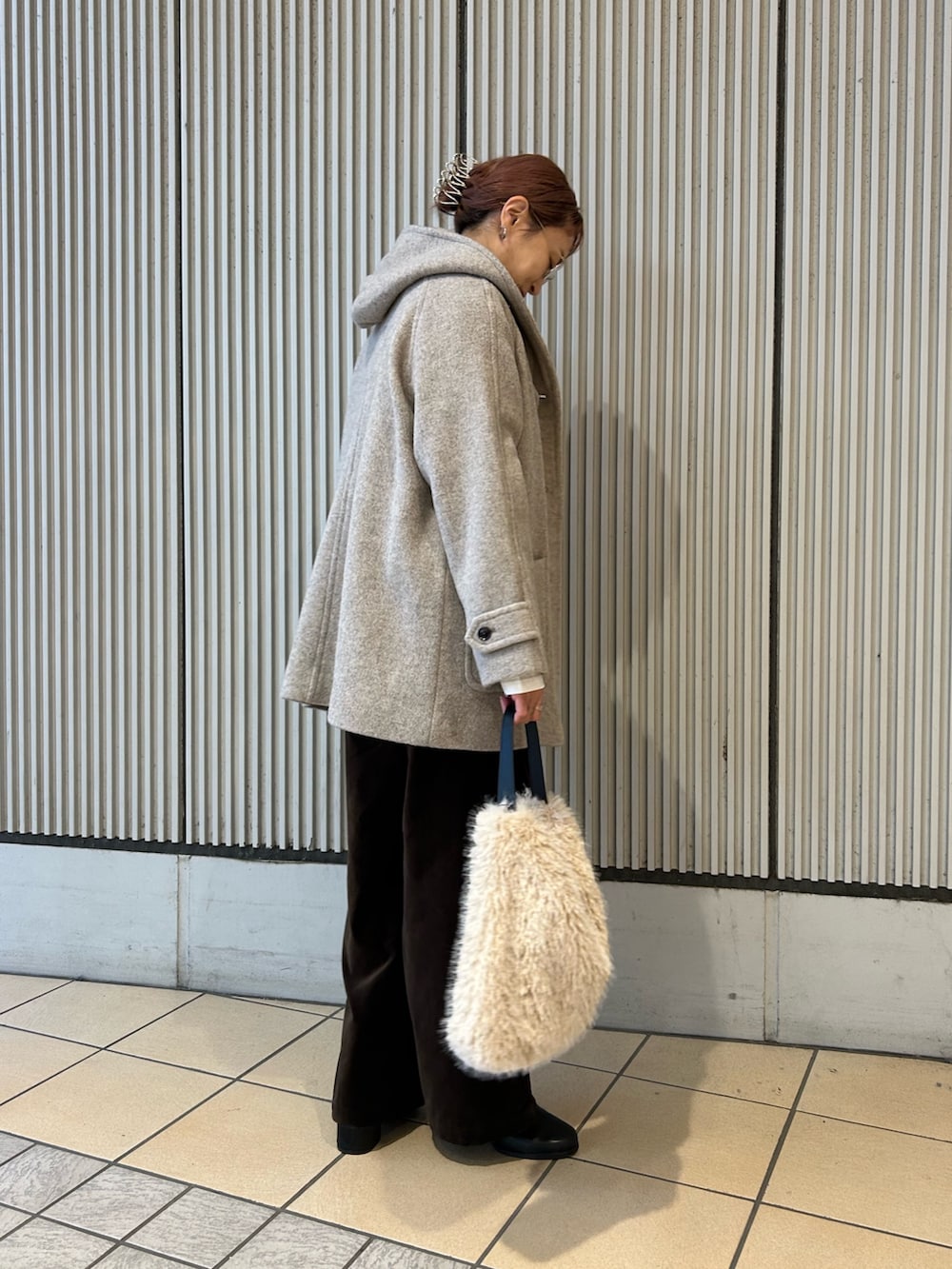 ホワイト系のニット/セーター、ブラウン系のその他パンツ、ブラック系のブーツを着用したレディースの秋コーディネートの2枚目の写真