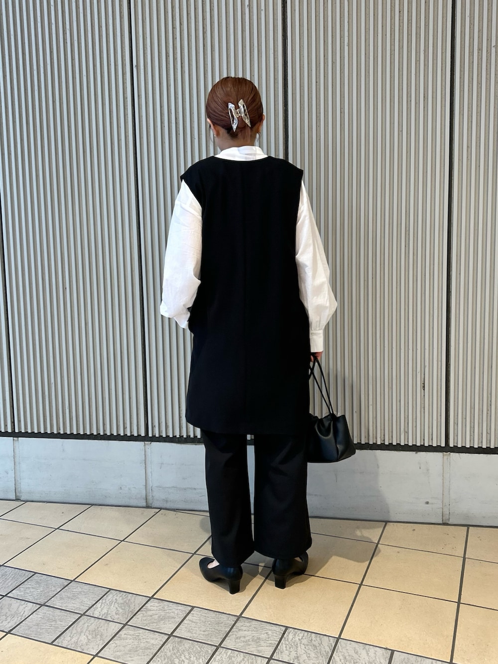 ブラック系のベスト、ブラック系のその他パンツ、ブラック系のパンプスを着用したレディースの冬コーディネートの2枚目の写真