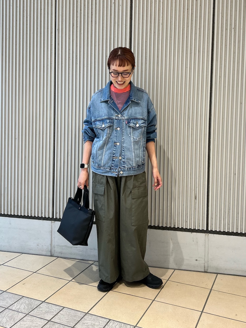 ブルー系のデニムジャケット、ピンク系のTシャツ/カットソー、グリーン系のその他パンツを着用したレディースの春コーディネートの4枚目の写真