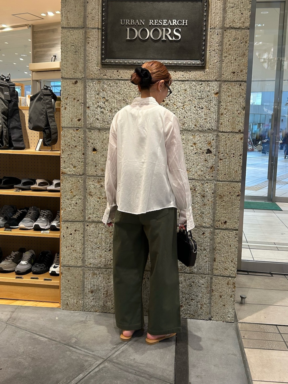 グリーン系のその他パンツ、ホワイト系のサンダル、ブラック系のショルダーバッグを着用したレディースの春コーディネートの2枚目の写真
