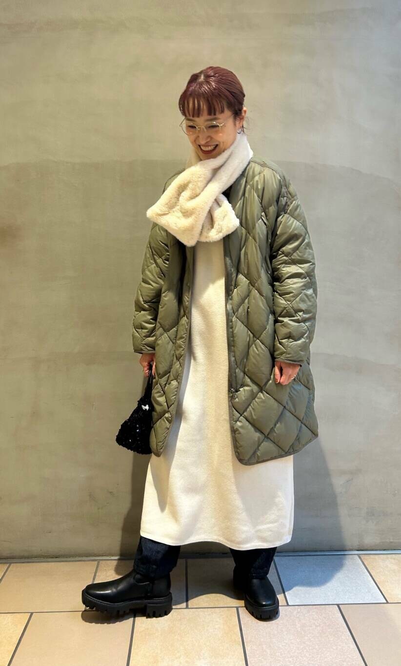 ブラック系のショルダーバッグ、グリーン系のダウンジャケット/コート、ブラック系のブーツを着用したレディースの冬コーディネートの3枚目の写真