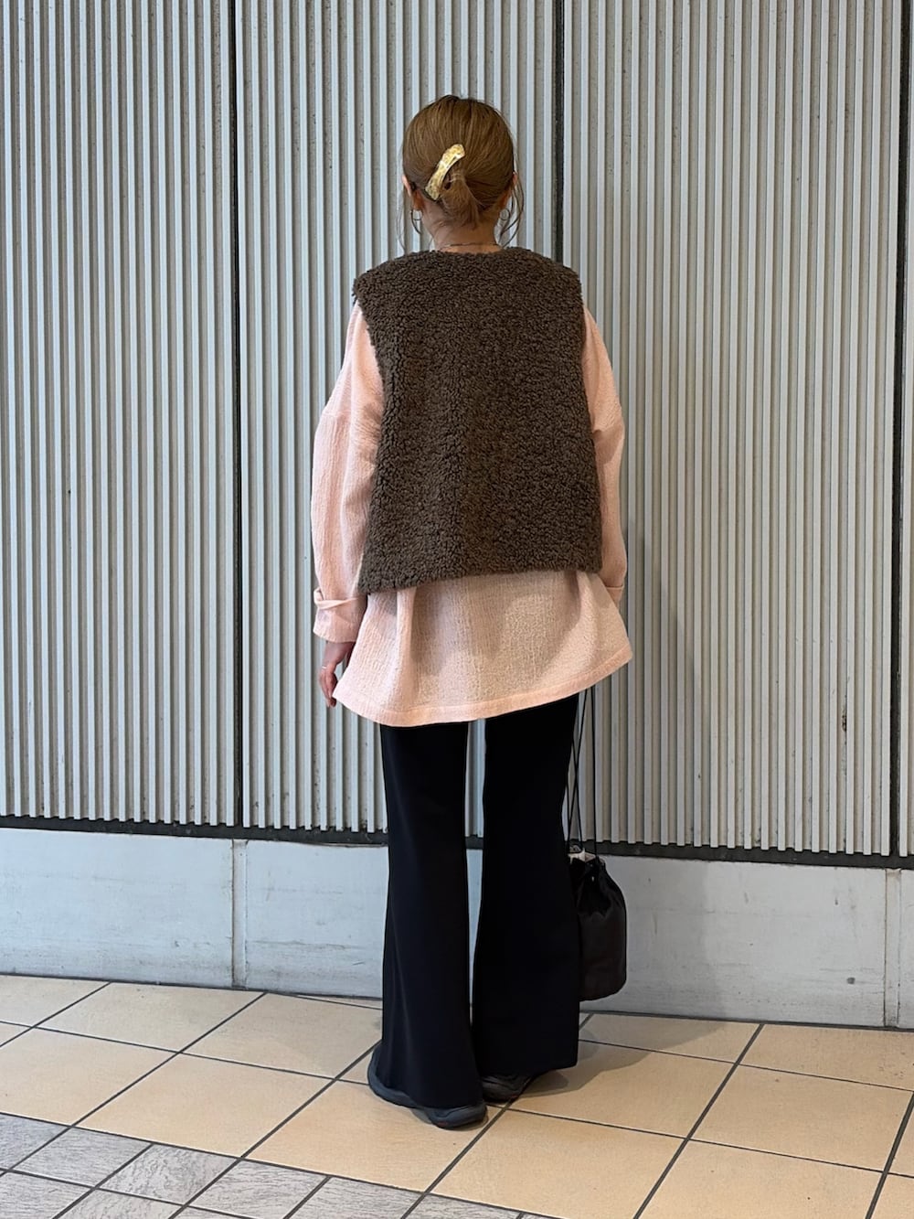 ピンク系のシャツ/ブラウス、ブラウン系のダウンベスト、ブラック系のその他パンツを着用したレディースの秋コーディネートの3枚目の写真