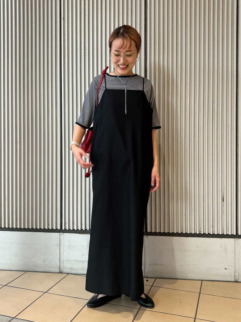 ブラック系のワンピース、グレー系のTシャツ/カットソー、レッド系のショルダーバッグを着用したレディースの夏コーディネートの3枚目の写真
