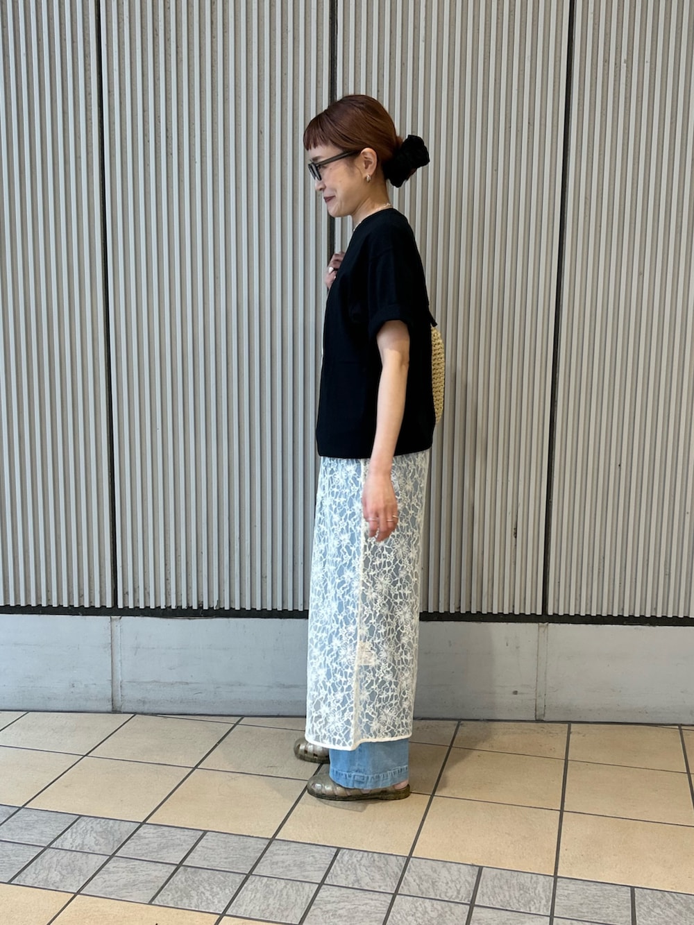 ブラック系のTシャツ/カットソー、ホワイト系のワンピース、ブルー系のデニムパンツを着用したレディースの春コーディネートの2枚目の写真