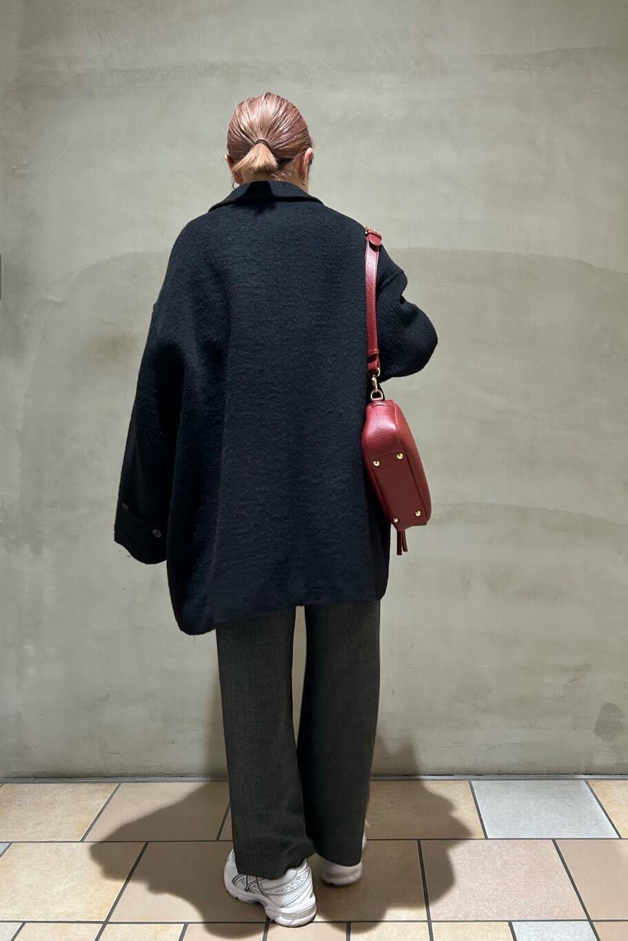 ブラック系のその他アウター、グレー系のサロペット/オーバーオール、レッド系のショルダーバッグを着用したレディースの冬コーディネートの2枚目の写真
