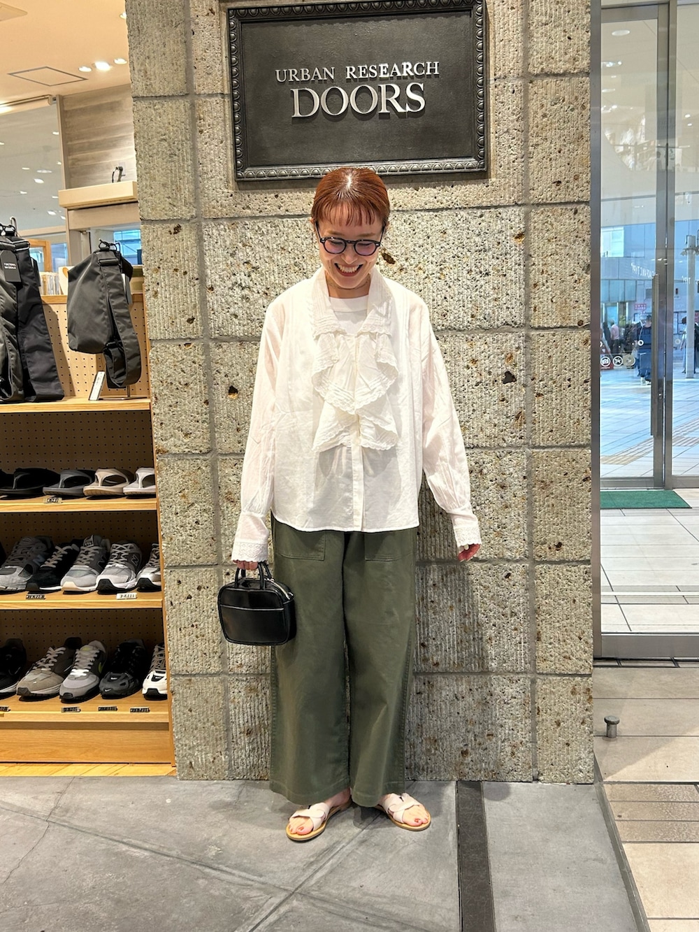 グリーン系のその他パンツ、ホワイト系のサンダル、ブラック系のショルダーバッグを着用したレディースの春コーディネートの4枚目の写真