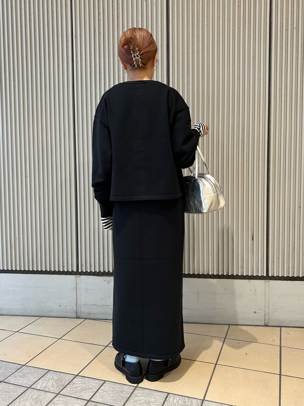 ブラック系のカーディガン/ボレロ、ブラック系のスカート、ホワイト系のTシャツ/カットソーを着用したレディースの秋コーディネートの3枚目の写真
