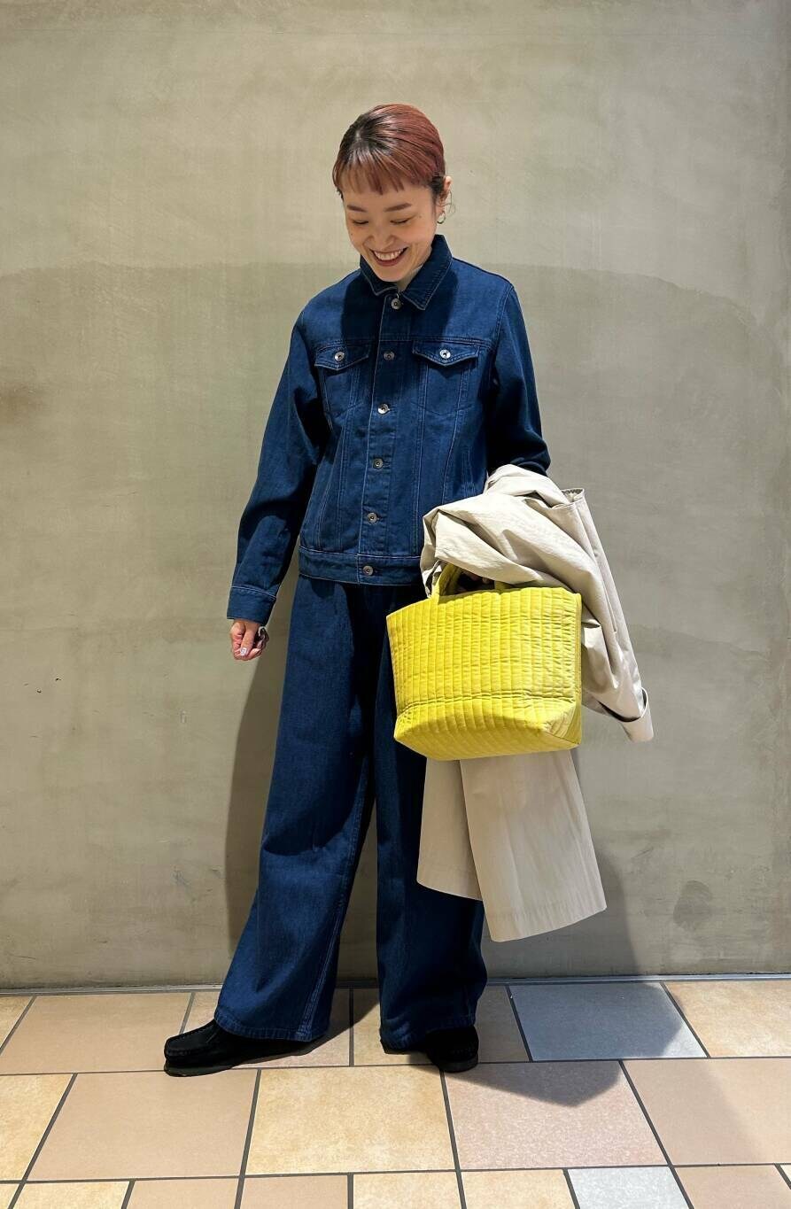 ブラック系のブーツ、イエロー系のトートバッグ、ブルー系のデニムパンツを着用したレディースの冬コーディネートの4枚目の写真