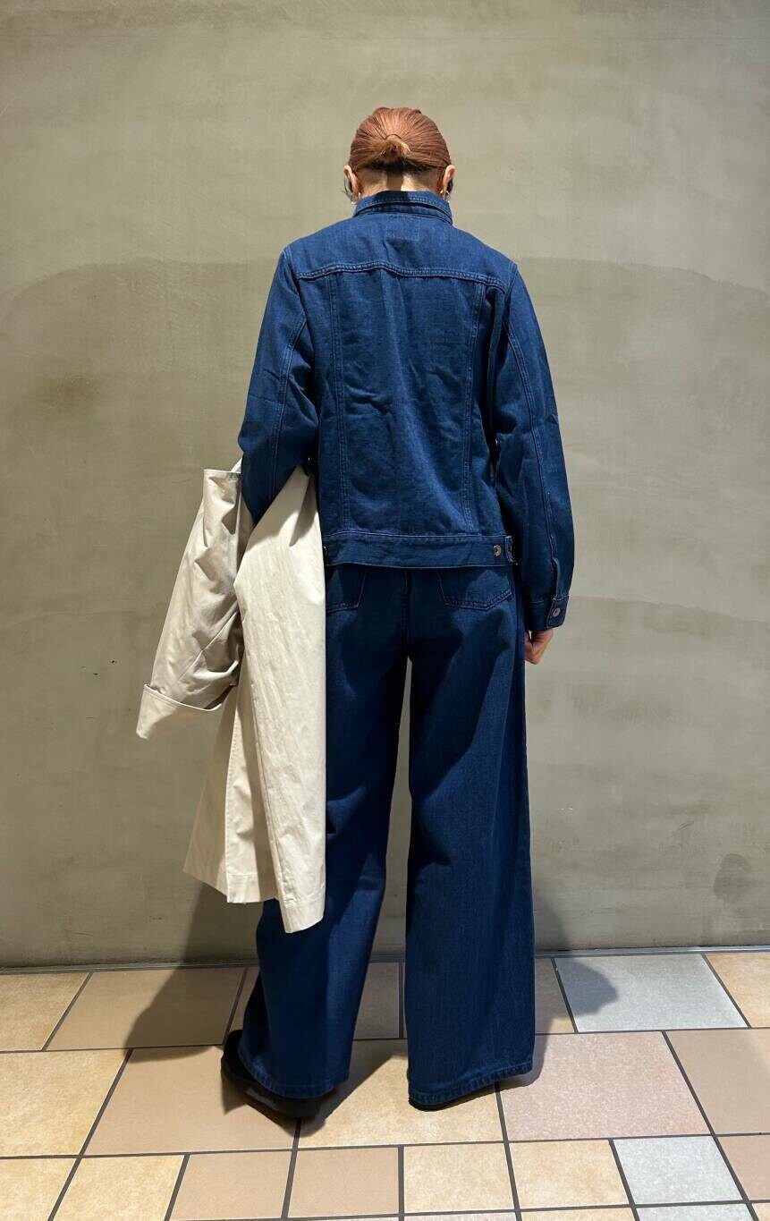 ブラック系のブーツ、イエロー系のトートバッグ、ブルー系のデニムパンツを着用したレディースの冬コーディネートの6枚目の写真