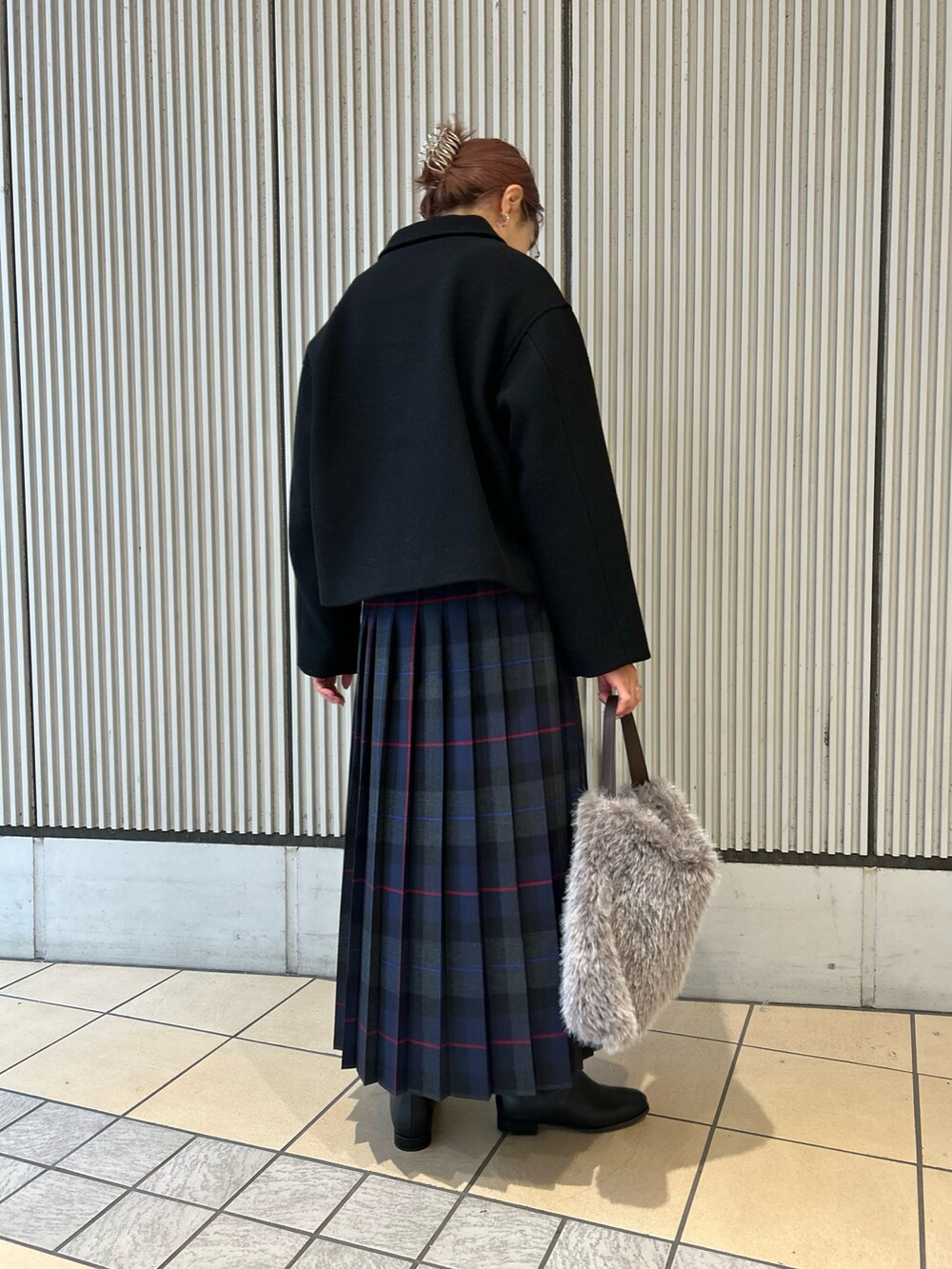 ブルー系のスカート、パープル系のニット/セーター、ブラック系のその他アウターを着用したレディースの秋コーディネートの5枚目の写真