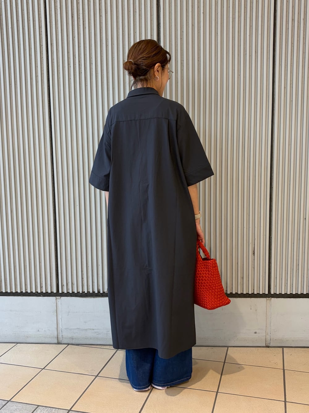 ブルー系のワンピース、ピンク系のスニーカー、レッド系のハンドバッグを着用したレディースの夏コーディネートの3枚目の写真